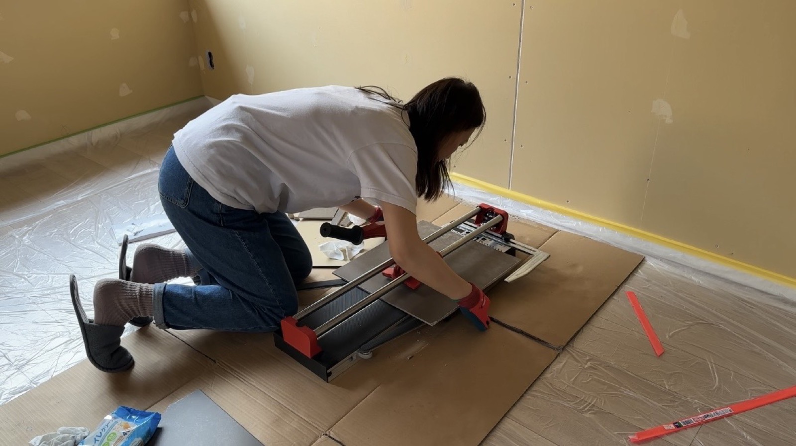 Minseon cutting tiles by hand during akiya bathroom restoration